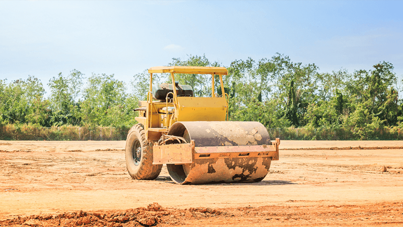 A Vibratory Roller Compacts Soil On A Construction Site